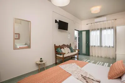 a bedroom with a bed and a mirror and a chair at Tersanas Sea Front Villas in Tersanas