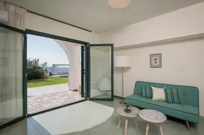 a living room with a couch and a sliding glass door at Tersanas Sea Front Villas in Tersanas