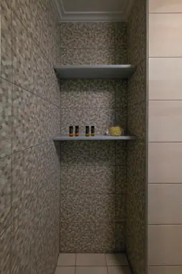 a bathroom with a shower with three bottles on a shelf at Elartis Apartment in Chania Town