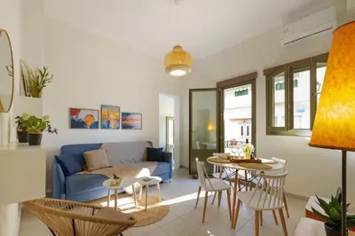 a living room with a blue couch and a table at Elartis Apartment in Chania Town