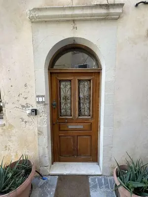 a wooden door in a stone building with plants at Casa Argirenia - Venetian Mansion in Old Harbour in Chania Town