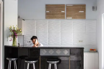 a man sitting at a counter in a kitchen at Blue Calm in Daratso