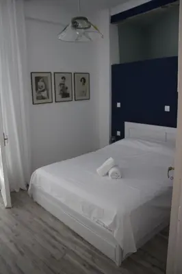 a bedroom with a white bed with two towels on it at Superior Apartment Near Beach in Chania Town