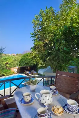 a table with cups and saucers on top of a balcony at Villa Olivo Kampani in CHQ