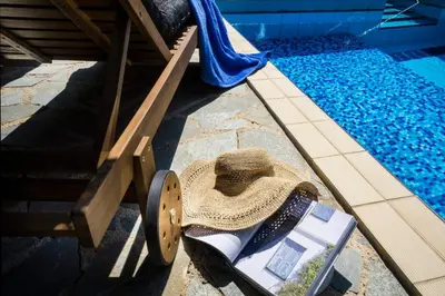 a straw hat sitting on the ground next to a swimming pool at Villa Olivo Kampani in CHQ
