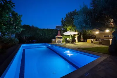 a swimming pool in a backyard at night at Villa Olivo Kampani in CHQ