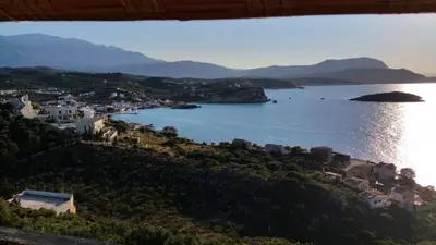 a view of a town and a body of water at Paradise in Áyios Andhréas