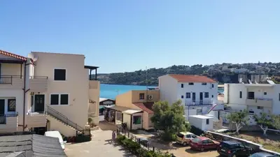 a group of buildings with cars parked in a parking lot at Paradise in Áyios Andhréas