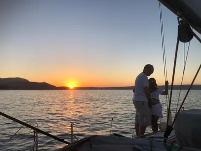 a man and a woman standing on a boat at sunset at Perseus Sailing Cruises in Souda