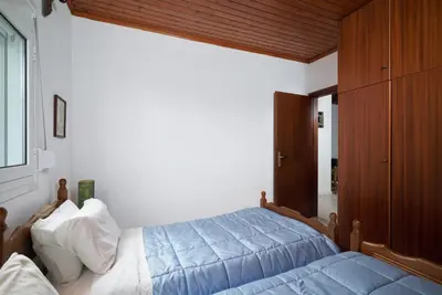 a bedroom with a bed with a blue comforter at Seaside House in Chania Town