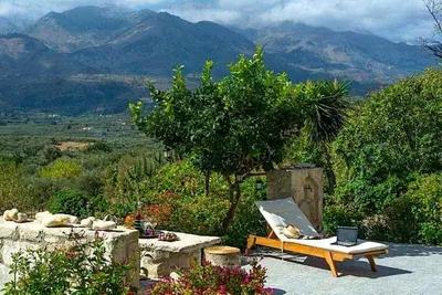 a bench and a laptop on a table with a mountain at Villa Iro - Private Pool & Tranquility in Káïna