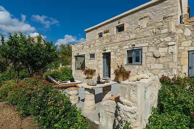 a stone house with a stone fence in front of it at Villa Iro - Private Pool & Tranquility in Káïna