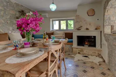 a dining room with a table and a fireplace at Villa Iro - Private Pool & Tranquility in Káïna