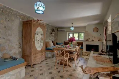 a living room with a table and a living room with a fireplace at Villa Iro - Private Pool & Tranquility in Káïna