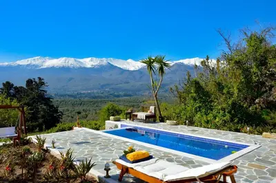 a swimming pool with a view of snowy mountains at Villa Iro - Private Pool & Tranquility in Káïna
