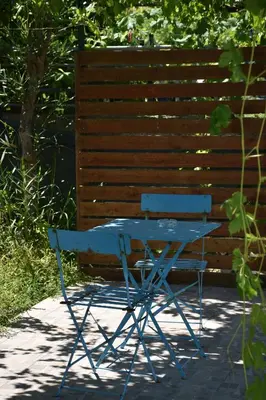 a blue table and a chair in front of a fence at Villa Gerani in Gerani Chanion