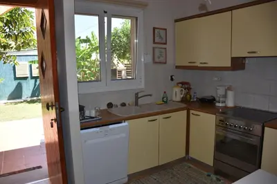 a kitchen with white cabinets and a sink and a window at Villa Gerani in Gerani Chanion