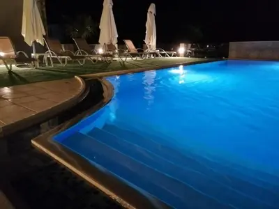 a swimming pool at night with blue lighting at Carisa Suites and Apartments in Maleme