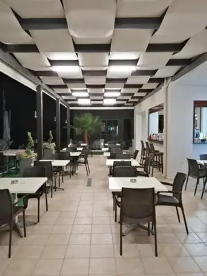 a dining room with tables and chairs in a restaurant at Carisa Suites and Apartments in Maleme