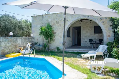 a patio with an umbrella and a swimming pool at Villa Antonia in Gramvousá