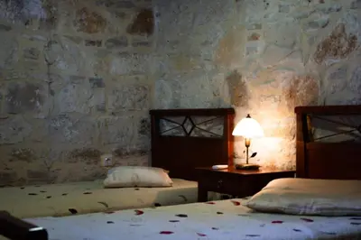 a bedroom with two beds and a table with a lamp at Villa Antonia in Gramvousá