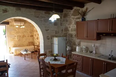 a kitchen with a table and a refrigerator in a room at Villa Antonia in Gramvousá
