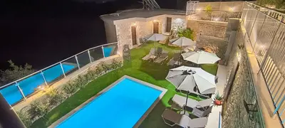 an aerial view of a house with a pool and umbrellas at Achlades The Mountain Paradise Villas - Studio with pool! in Aletrouvárion