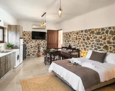 a bedroom with a king sized bed and a kitchen at Achlades The Mountain Paradise Villas - Suite with pool and balcony with amazing view! in Aletrouvárion