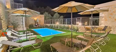 a pool with chairs and umbrellas in a yard at Achlades The Mountain Paradise Villas - Suite with pool and balcony with amazing view! in Aletrouvárion