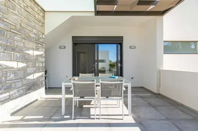a white table and chairs on a patio at Menta Villa by Vintage Travel in Tavronitis