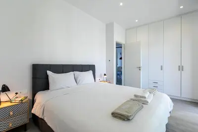 a bedroom with a large white bed with a black headboard at Menta Villa by Vintage Travel in Tavronitis
