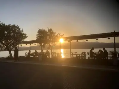 a group of people sitting at a bar at sunset at Menta Villa by Vintage Travel in Tavronitis
