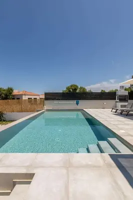 a swimming pool with blue water in a yard at Menta Villa by Vintage Travel in Tavronitis