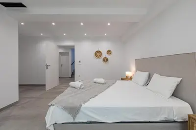 a bedroom with a large white bed with white pillows at Myrtle Villa by Vintage Travel in Tavronitis