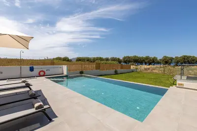 a swimming pool in a yard with an umbrella at Myrtle Villa by Vintage Travel in Tavronitis