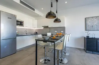 a kitchen with a table with chairs and a refrigerator at Sage Villa by Vintage Travel in Tavronitis