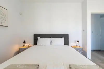 a bedroom with a large white bed with two lamps at Sage Villa by Vintage Travel in Tavronitis