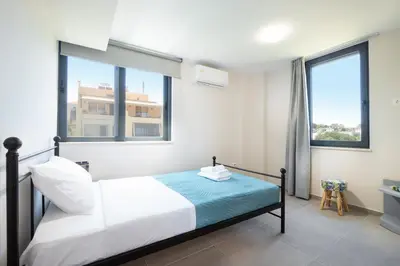 a bedroom with a bed and two windows at Didas Serenity Breeze in Kounoupidhianá