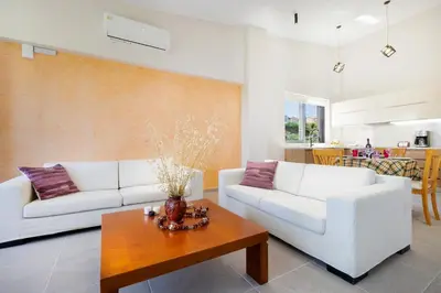 a living room with two white couches and a table at Didas Serenity Breeze in Kounoupidhianá