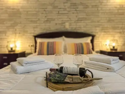 a hotel room with a bed with towels and wine glasses at Achlades The Mountain Paradise Villas - Suite with a Private Jacuzzi, Pool, and a Balcony with an Amazing View! in Aletrouvárion