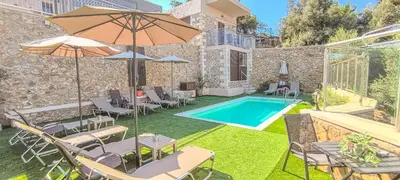 a backyard with a swimming pool with chairs and an umbrella at Achlades The Mountain Paradise Villas - Suite with a Private Jacuzzi, Pool, and a Balcony with an Amazing View! in Aletrouvárion