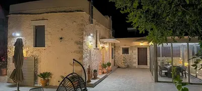 a courtyard of a building with a table and chairs at Achlades The Mountain Paradise Villas - Suite with a Private Jacuzzi, Pool, and a Balcony with an Amazing View! in Aletrouvárion