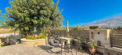 a patio with a table and chairs and a fence at Achlades The Mountain Paradise Villas - Suite with a Private Jacuzzi, Pool, and a Balcony with an Amazing View! in Aletrouvárion