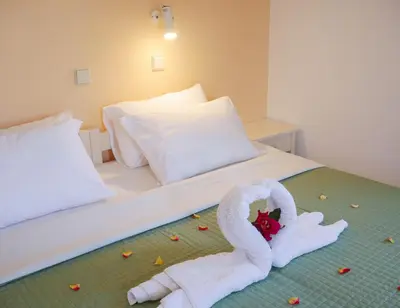 a bed with a swan made out of towels at Nik Litinas Apartments with pool in Plataniás