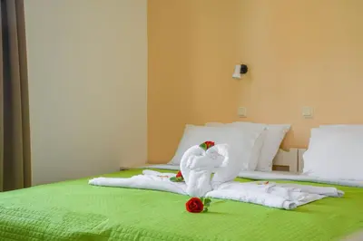 a bed with two swans made out of towels at Nik Litinas Apartments with pool in Plataniás