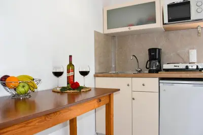 a kitchen with a counter with two glasses of wine at Nik Litinas Apartments with pool in Plataniás