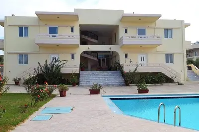 a large house with a swimming pool in front of it at Nik Litinas Apartments with pool in Plataniás