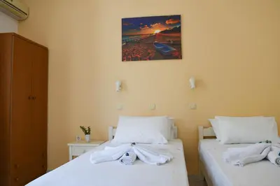 two beds in a room with towels on them at Nik Litinas Apartments with pool in Plataniás