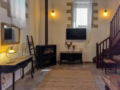 a living room with a television and a fireplace at Achlades The Mountain Paradise Villas - Maisonette with pool and amazing view! in Aletrouvárion