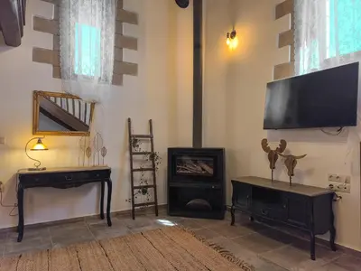 a living room with a fireplace and a flat screen tv at Achlades The Mountain Paradise Villas - Maisonette with pool and amazing view! in Aletrouvárion